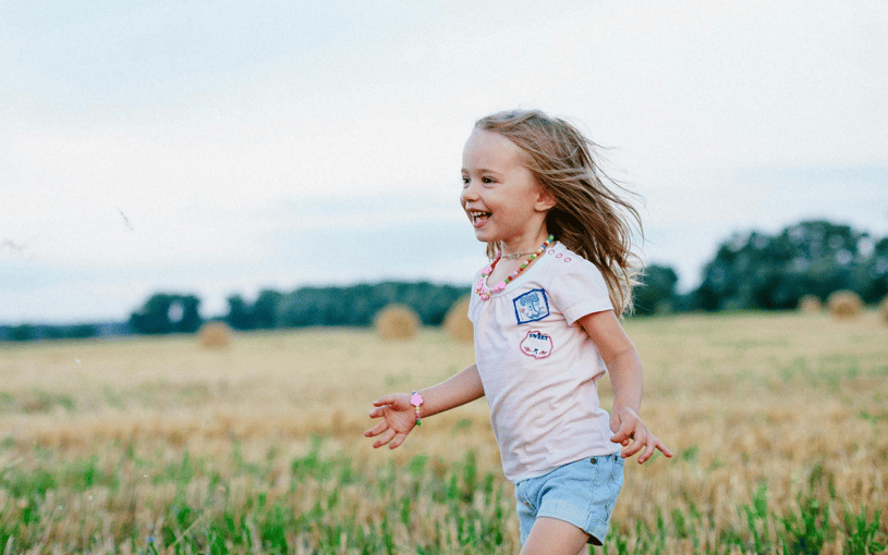 happy child running through a field