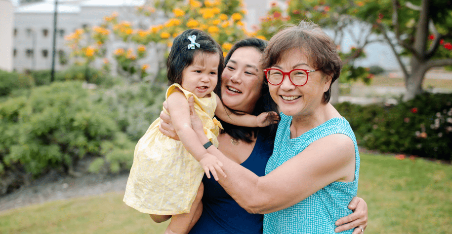 Mom and grandparent smiling for a photo with their daughter/granddaughter