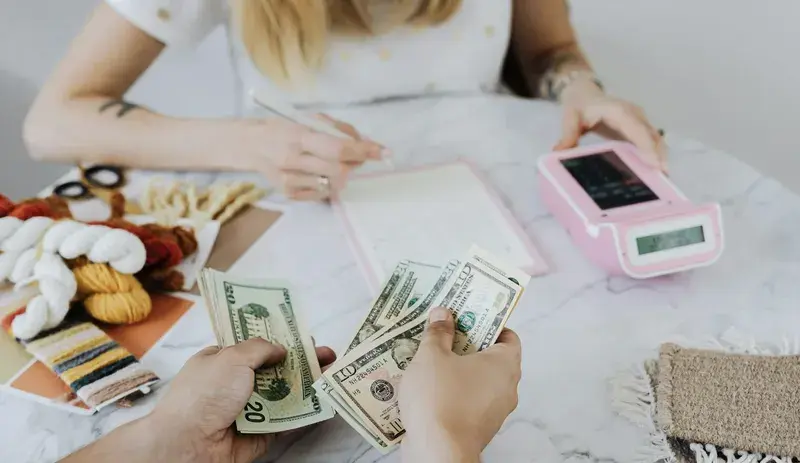 Two people counting money for primary savings