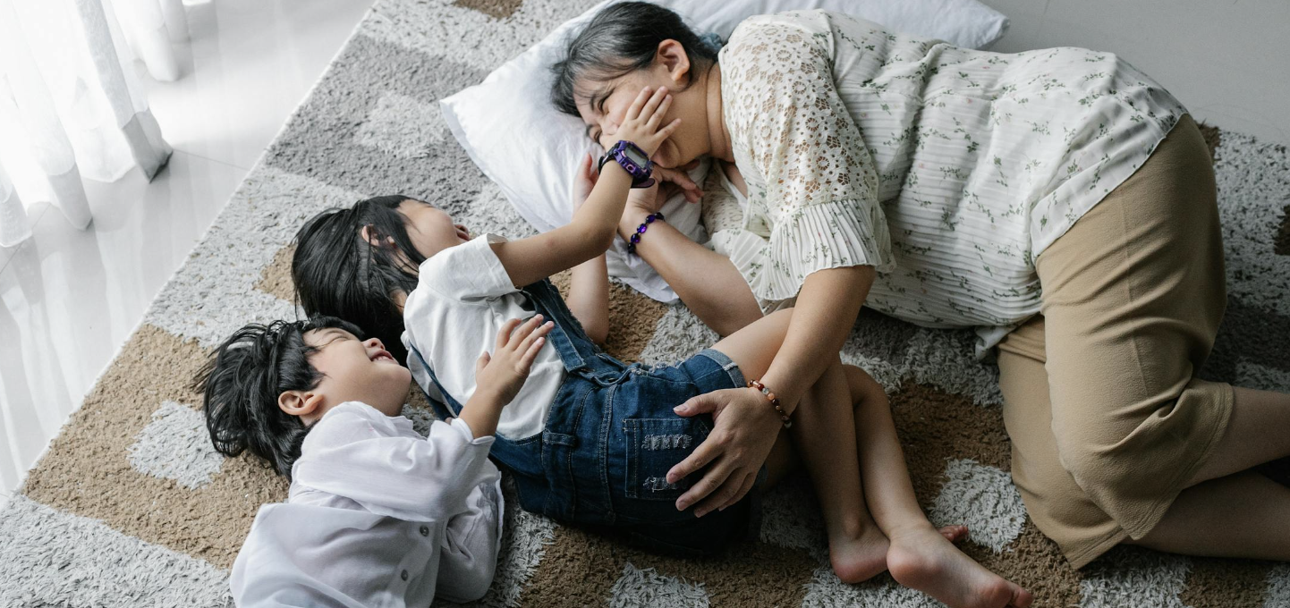 grandma playing on the ground with her granddaughters