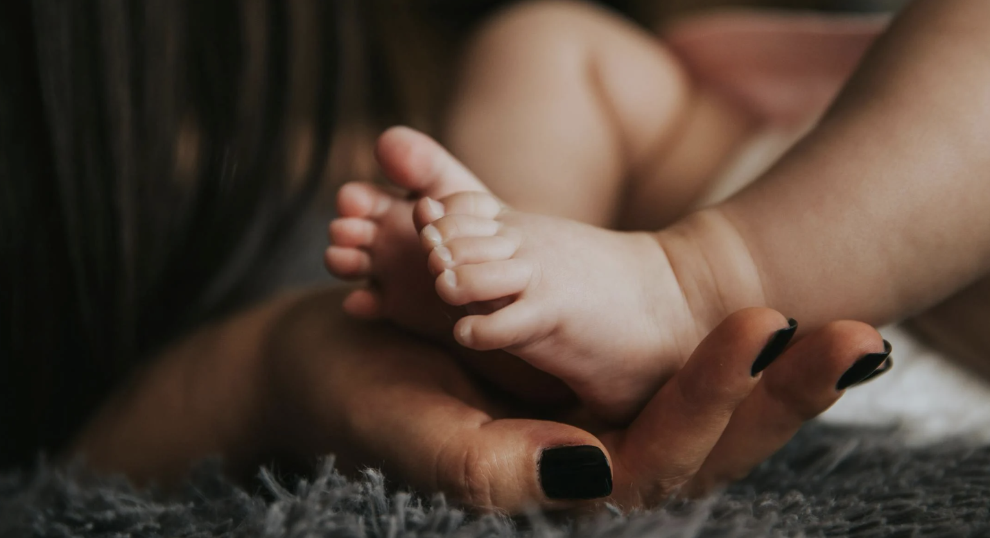 a baby's small foot in his mother's hand