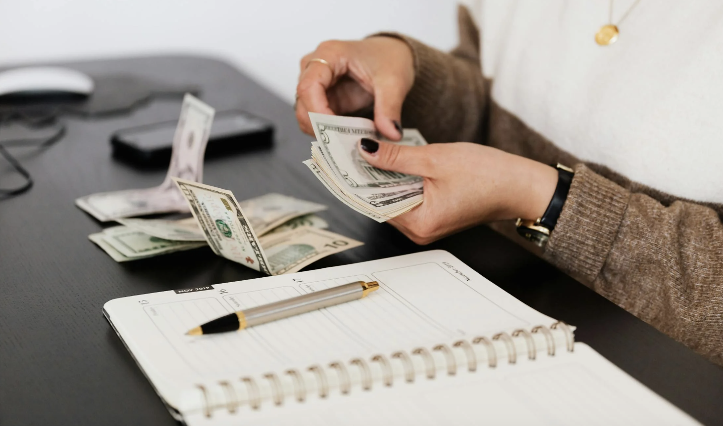 woman counting bills to see how much she has saved