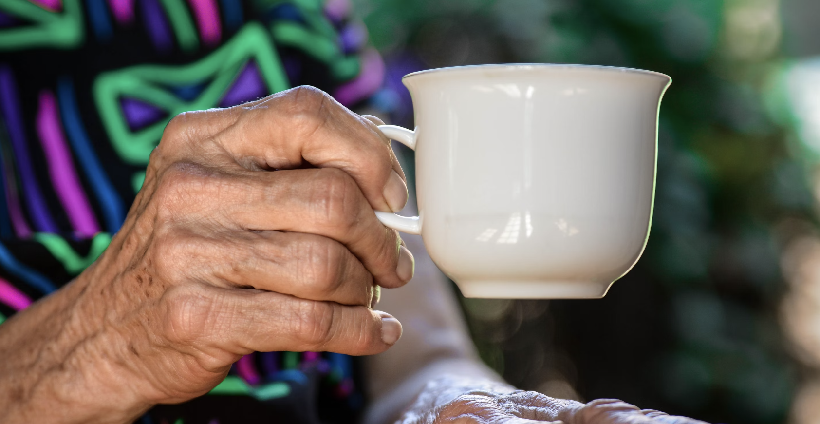 elderly woman holding a cup of tea