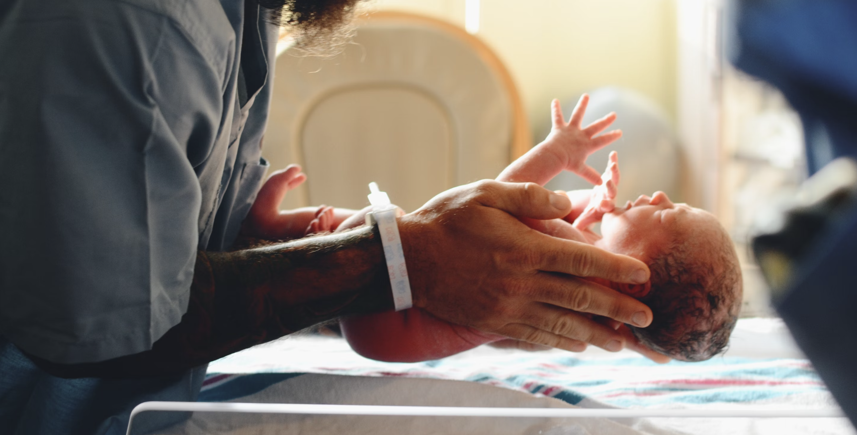 father holding newborn baby in the hospital