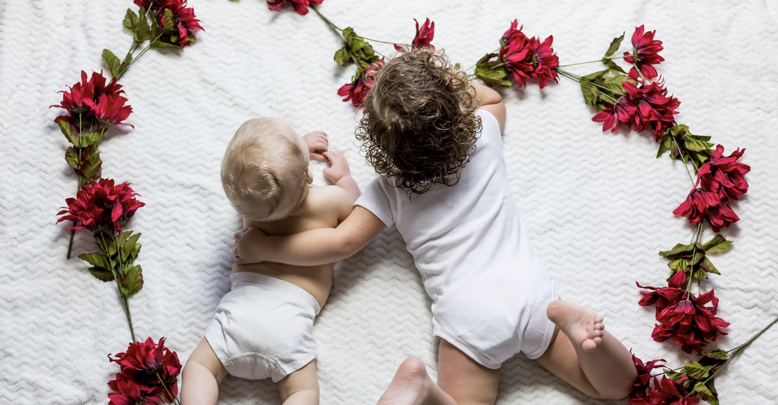 baby and sibling lying on their tummies