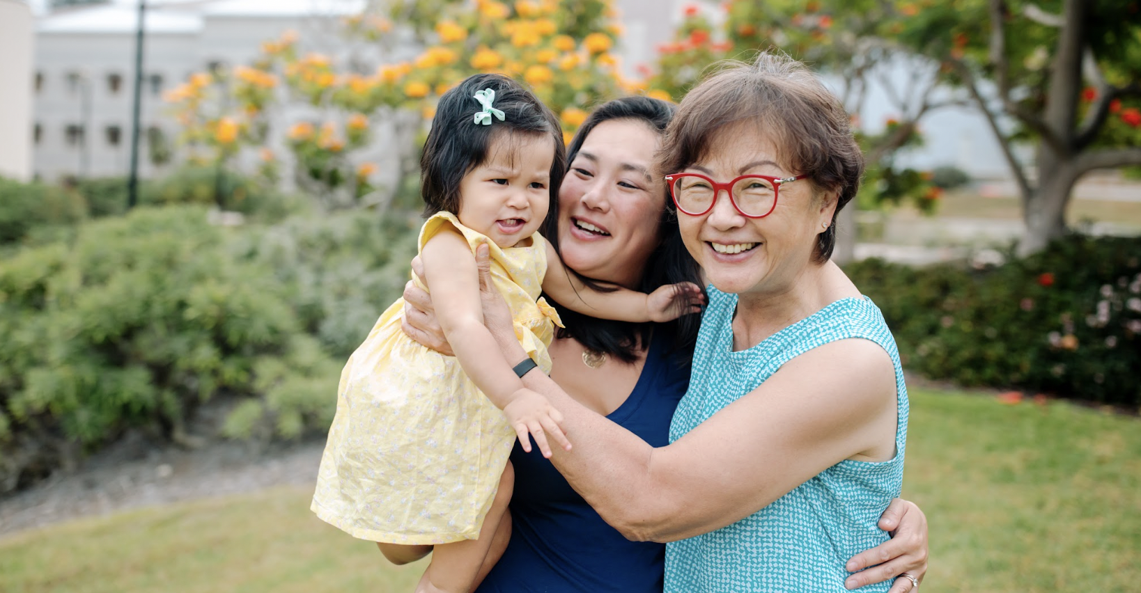 Mom and grandparent smiling for a photo with their daughter/granddaughter 