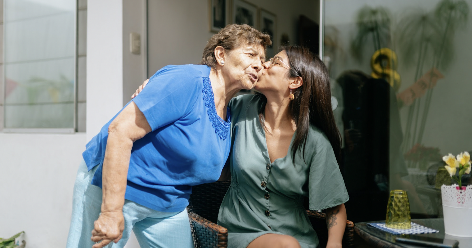 Daughter kissing her older mother on the cheek 