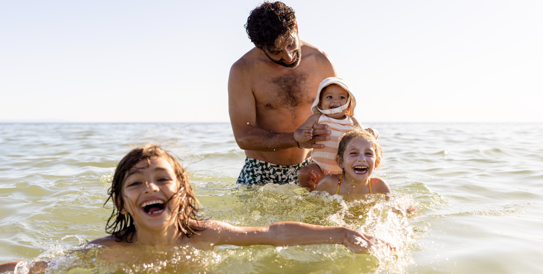 A dad with his young children enjoying the water